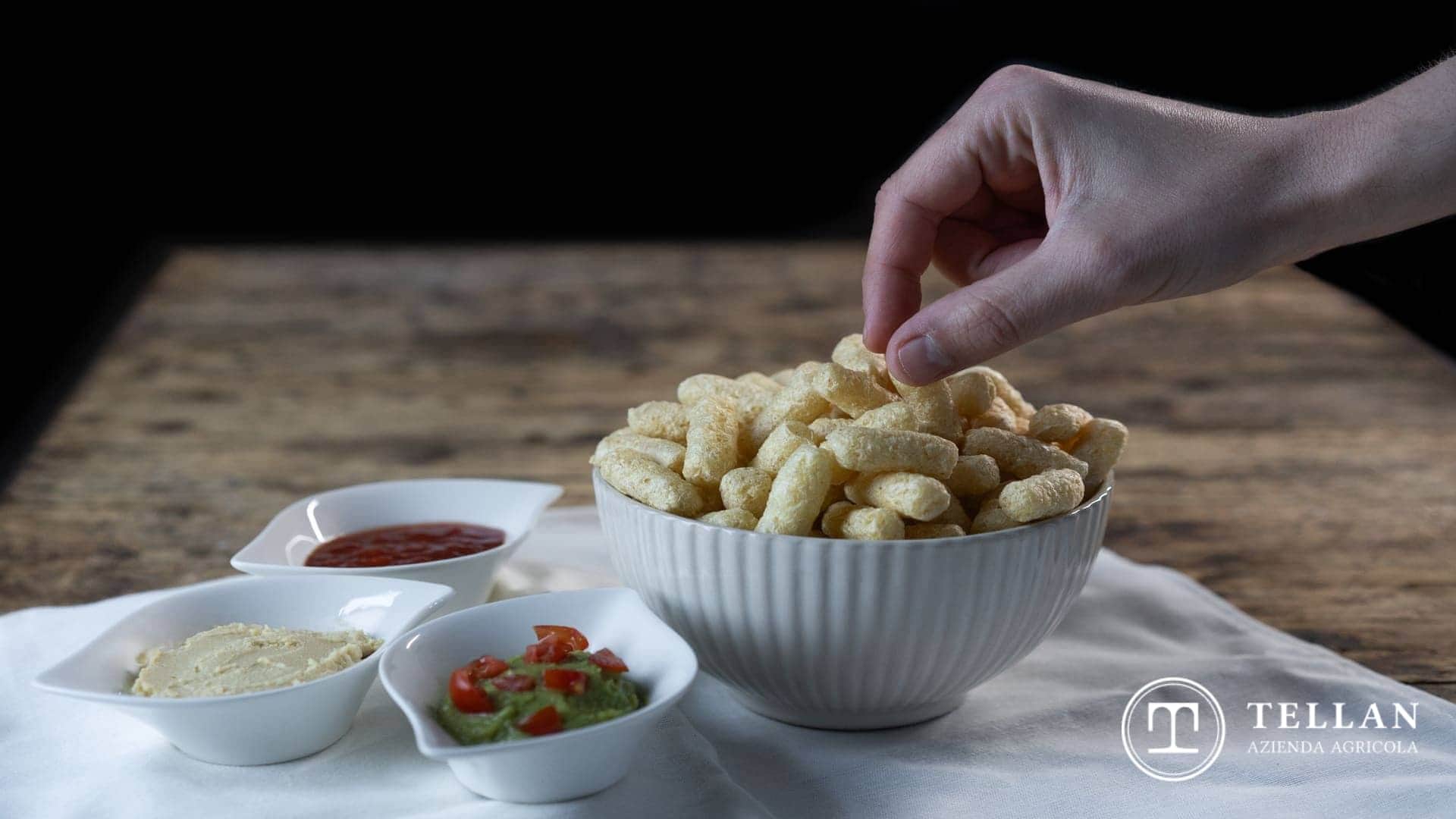Ciotola con cornetti di mais e altre ciotole con salse da abbinamento