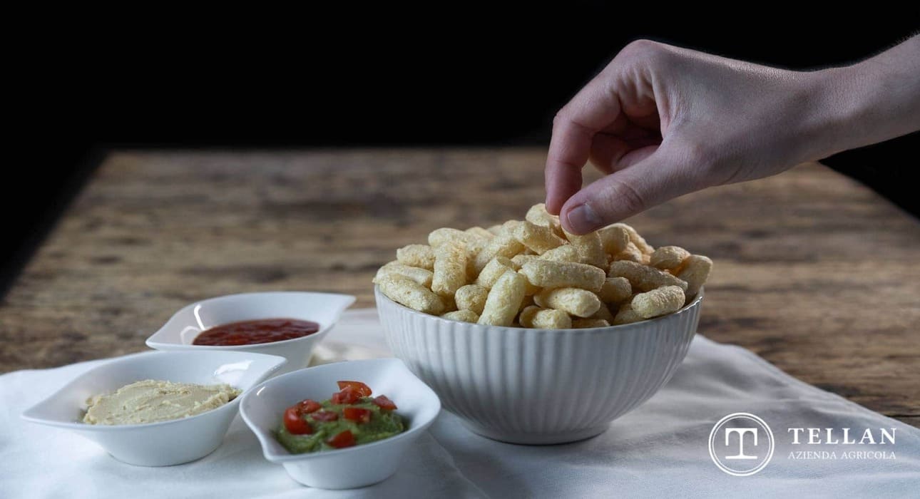 Ciotola con cornetti di mais e altre ciotole con salse
