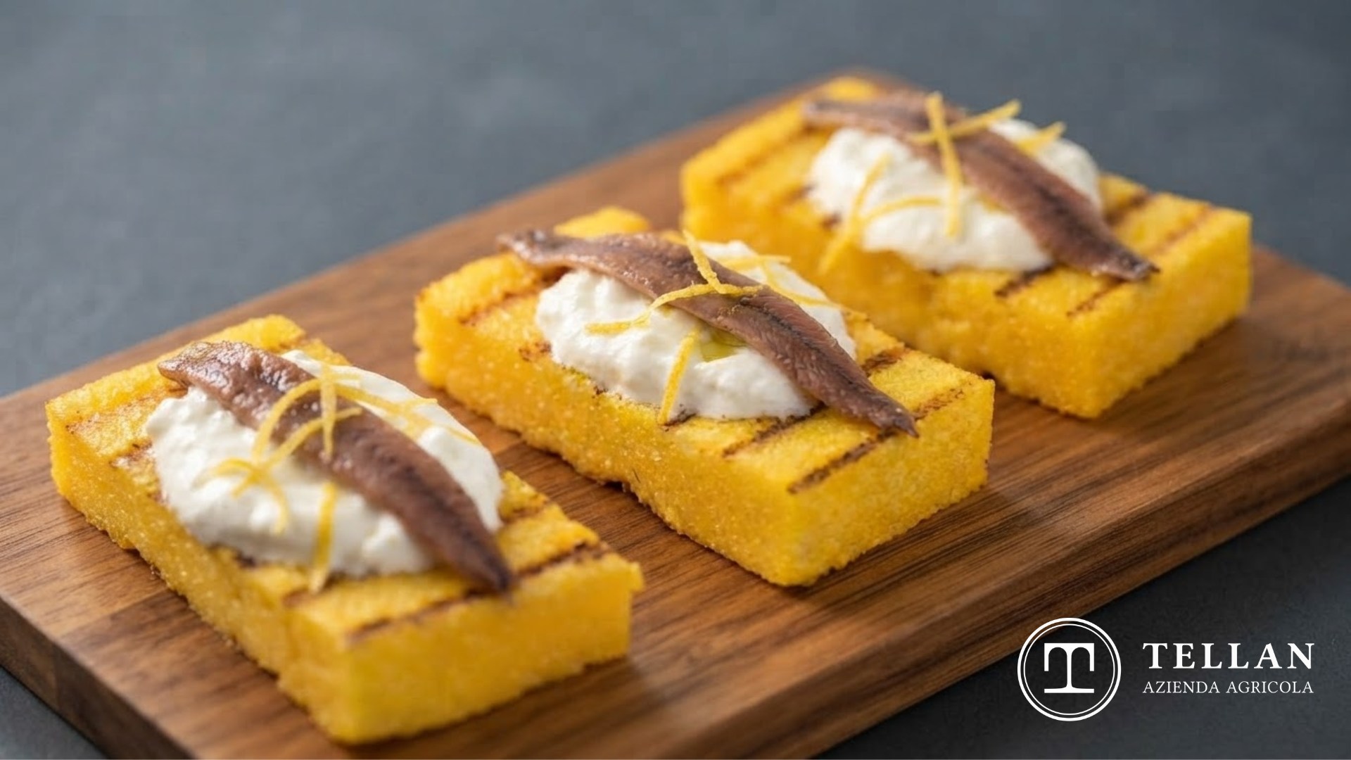polenta gourmet su un tagliere di legno con sopra acciughe e burrata